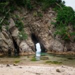 A large rock formation with a cave in the middle of it